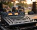 Mixer audio analog dengan fader dan knob saat soundcheck di panggung event outdoor